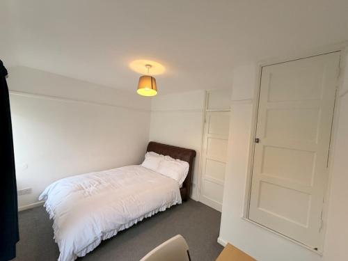 a bedroom with a white bed and a door at Precious House 2 in Leicester