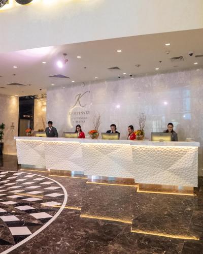 a group of people sitting at a counter in a lobby at Kempinski Residences & Suites, Doha in Doha
