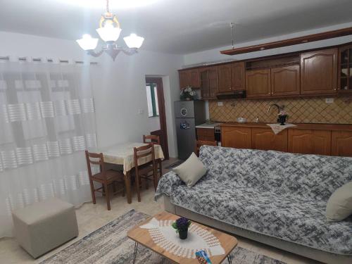 una sala de estar con un sofá y una mesa y una cocina en Oremari Home, en Korçë