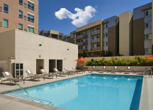 a swimming pool with lounge chairs and a building at Hyatt House LA - University Medical Center in Los Angeles