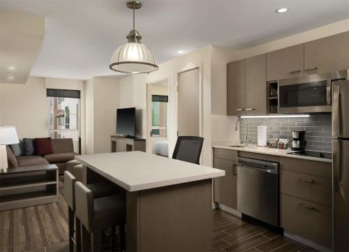 a kitchen and living room with a kitchen island in a room at Hyatt House LA - University Medical Center in Los Angeles