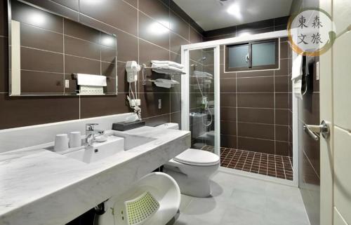 a bathroom with a sink and a toilet and a shower at 蝴蝶結溜滑梯親子民宿-寵物友善-無門禁24小時進出-免費停車-東森文旅-包棟優惠中 in Yuanshan