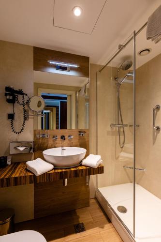 a bathroom with a sink and a shower and a tub at Avalon Hotel & Conferences in Riga