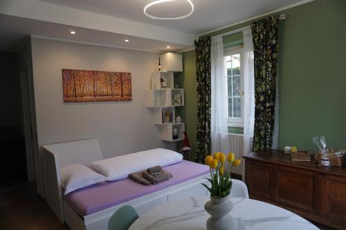 a room with a bed with a table and a painting at Dimora degli Gnomi in Tirano