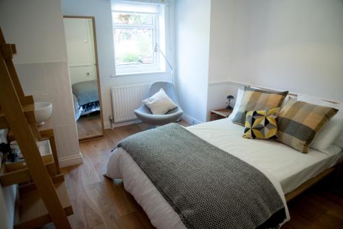 a bedroom with a bed and a chair and a window at Hathersage B & B in Hathersage