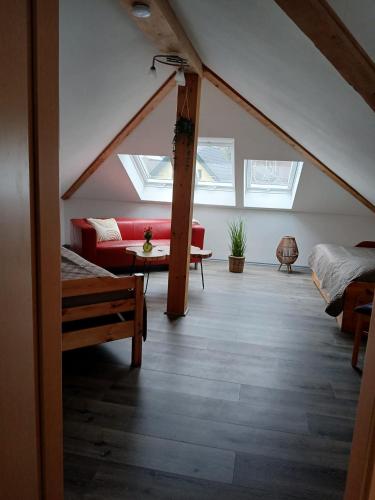 a attic room with a red couch and skylights at Feriendomizil-Stegemann in Trassenheide