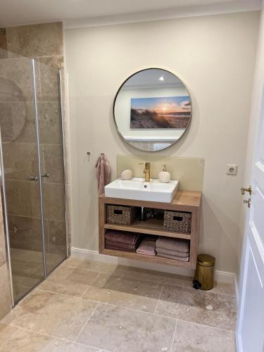 a bathroom with a sink and a mirror at Ferienhaus in idyllischer Lage - Ankommen & durchatmen in Humptrup