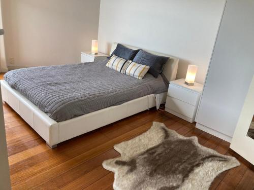 a bedroom with a bed with two night stands and a rug at St Kilda absolute beachfront views in Melbourne