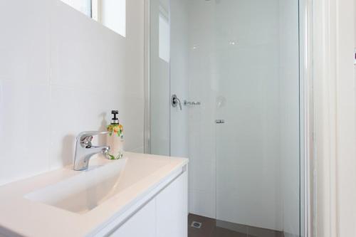 a bathroom with a sink and a shower at St Kilda absolute beachfront views in Melbourne