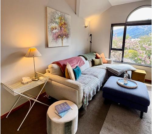 a living room with a couch and a table at Sun Views Forest yet close to town in Queenstown