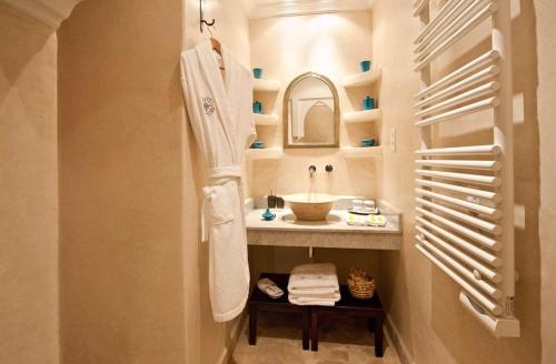 een badkamer met een wastafel, een spiegel en een handdoek bij Riad La Villa Marrakech in Marrakesh