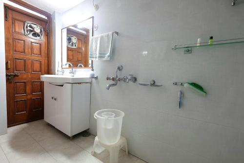 a bathroom with a toilet and a sink and a mirror at Matrika Rooms in Lucknow