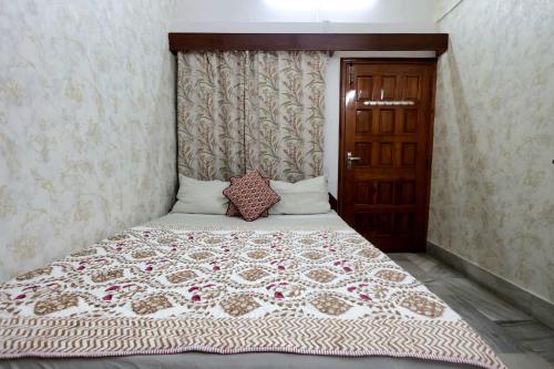 a bedroom with a large bed with a floral bedspread at Matrika Rooms in Lucknow