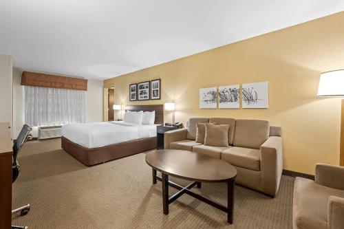 a hotel room with a bed and a couch at Sleep Inn & Suites Jasper I-22 in Jasper
