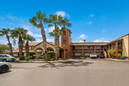 a parking lot in front of a hotel with palm trees at Quality Inn & Suites Goodyear - Phoenix West in Goodyear