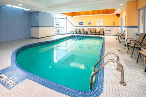 a pool in a hotel room with chairs and tables at Comfort Hotel & Suites in Peterborough