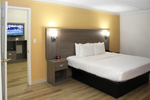 a hotel room with a bed and a television at Quality Inn Aurora Denver in Aurora