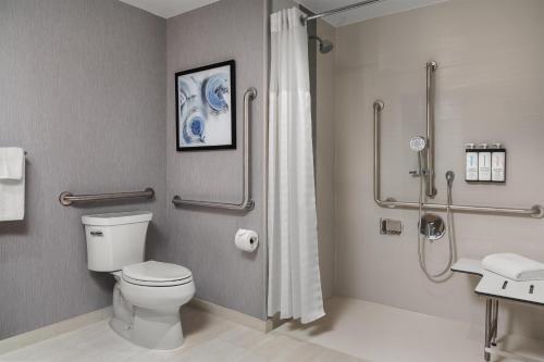 a bathroom with a toilet and a shower at Hyatt Place Toronto Airport in Toronto
