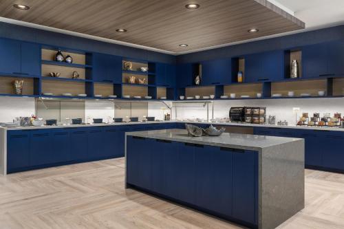 a large kitchen with blue cabinets and a large island at Hyatt Place Toronto Airport in Toronto