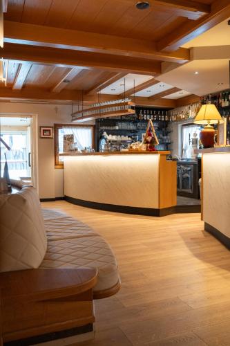a restaurant with a bar in the middle of a room at Hotel La Montanara Predazzo in Predazzo