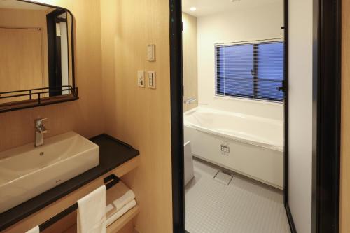 a bathroom with a sink and a toilet and a tub at HATAGO HIKONE - Main building in Hikone