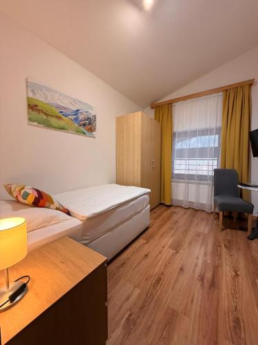 a bedroom with a bed and a desk and a chair at Hotel HAAS in Bad Gastein