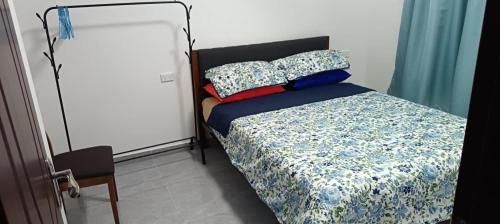 a bedroom with a bed with a blue comforter and pillows at Capital Transit Hub in Port Moresby