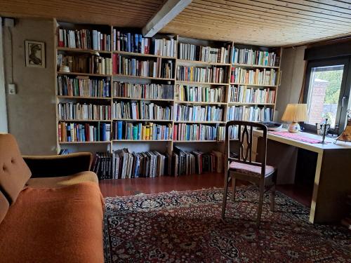a library with a desk and a chair in a room at Haus an der Stadtmauer in Lychen