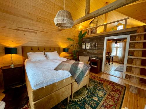 a bedroom with a bed in a wooden room at Torppa, puusauna ja ulkoporeallas in Lahti