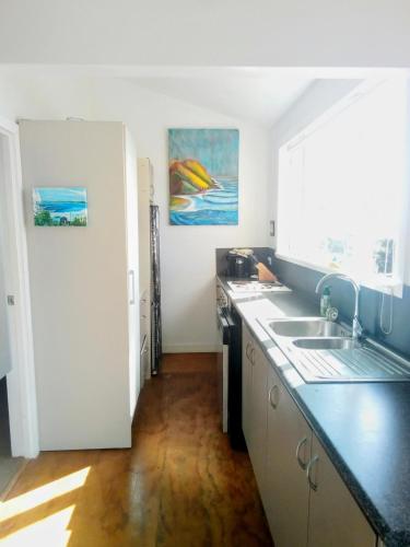 a kitchen with a sink and a counter top at Ahu in Piha