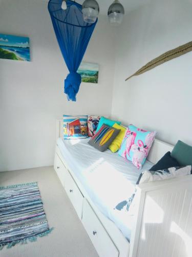 a bedroom with a bed with a blue umbrella on it at Ahu in Piha