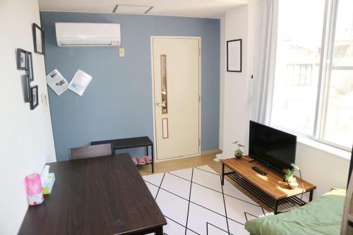 a living room with a table and a television at Joinus Ise Apartment by Tranova in Ise