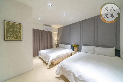 a hotel room with two beds and a mirror at 遇見礁溪-寵物友善-免費停車-無門禁24小時進出-東森文旅-包棟優惠中 in Jiaoxi