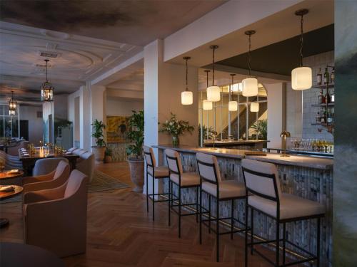 a bar in a restaurant with chairs and tables at The Bellevue Hotel, in the Unbound Collection by Hyatt in Philadelphia