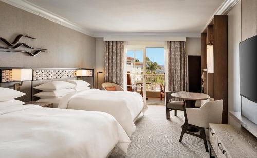 a hotel room with four beds and a television at Park Hyatt Aviara in Carlsbad