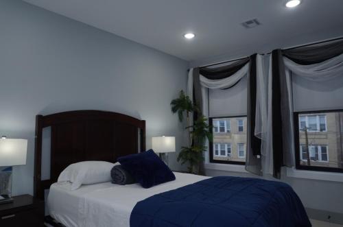 a bedroom with a large bed with two windows at Big apple room 33 in West New York