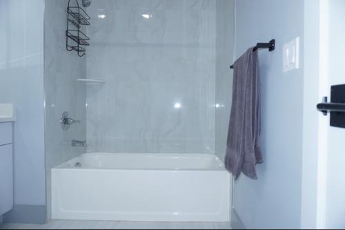 a white bathroom with a shower with a shower curtain at Big apple room 33 in West New York