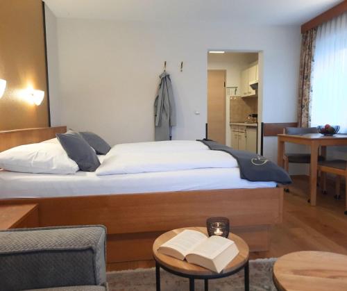 a bedroom with a bed and a table with two books at Appartementhaus Gaby in Bad Füssing