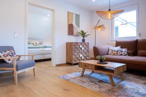 a living room with a couch and a coffee table at Heimbi Home No 2 I 4-5 Personen I Familienfreundlich I Balkon I Nähe EuropaPark I Parkplatz I E Ladestation in Schwanau