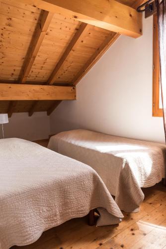 two beds in a room with wooden ceilings at L'Aurore du Lac in Sévrier