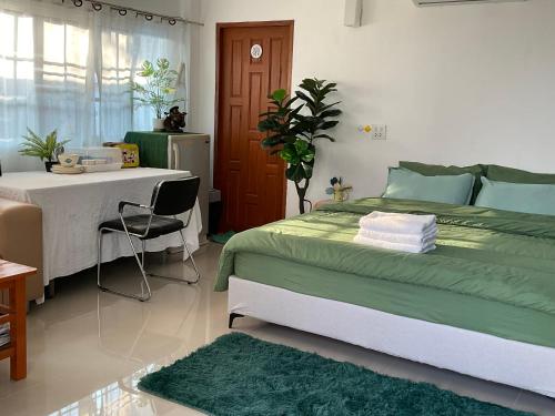 a bedroom with a bed and a table and a chair at พี เจ เอ็ม โฮมสเตย์ in Ban Nong Chaeng