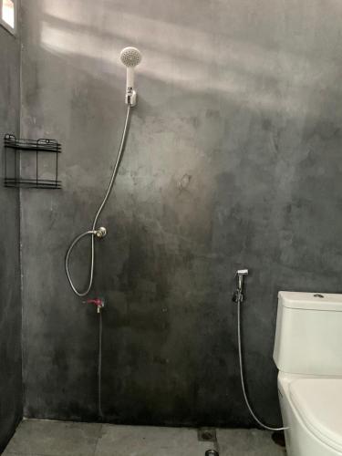 a shower in a bathroom with a toilet at พี เจ เอ็ม โฮมสเตย์ in Ban Nong Chaeng