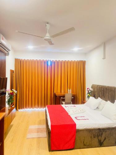 a bedroom with a large bed with a red blanket at REEF VIEW Beach Hotel in Matara