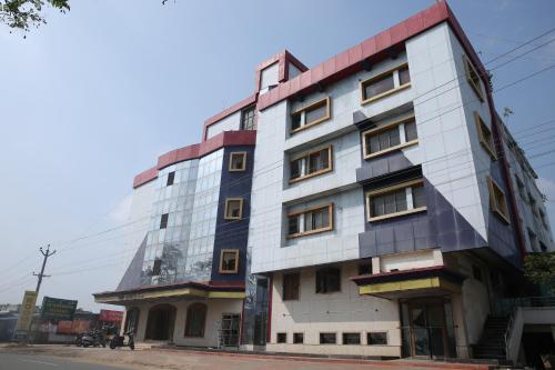 a tall white building on the side of a street at Sai Kirshanth Residency in Karaikal
