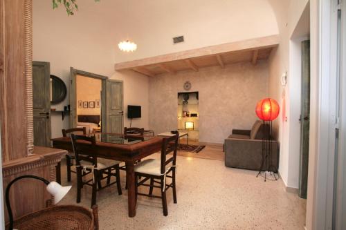 ein Wohnzimmer mit einem Holztisch und Stühlen in der Unterkunft Osterio Magno in Cefalú