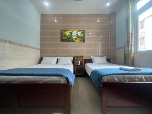 a bedroom with two beds and a window at Kim Long Hotel in Can Tho