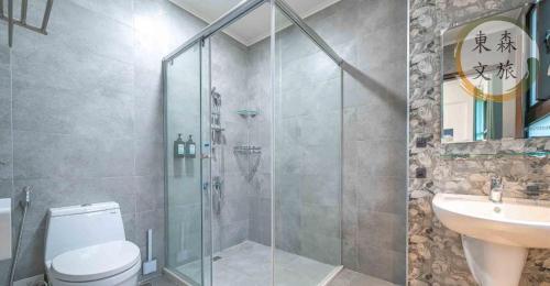 a bathroom with a shower and a toilet and a sink at 象日葵民宿-寵物友善-無門禁24小時進出-免費停車-東森文旅-包棟優惠中 in Wujie