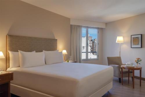 a hotel room with a large bed and a window at NH Córdoba Panorama in Córdoba