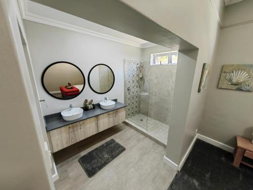 a bathroom with two sinks and a shower at Karibu Self-catering Accommodation in Hermanus