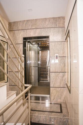 a staircase in a building with a metal elevator at Hotel Koyla Boarding and Lodging in Chikmagalūr